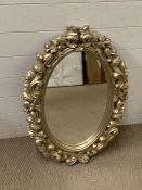 An oval mirror with carved foliage surround (80cm x 55cm)