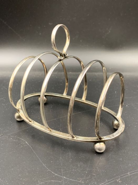 A silver toast rack , hallmarked for Birmingham 1929 by George Unite & Sons & Lyde Ltd.