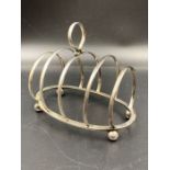 A silver toast rack , hallmarked for Birmingham 1929 by George Unite & Sons & Lyde Ltd.