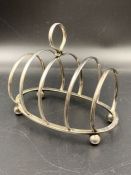 A silver toast rack , hallmarked for Birmingham 1929 by George Unite & Sons & Lyde Ltd.