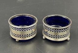 A pair of hallmarked silver salts with blue glass liners by Adie Brothers Ltd