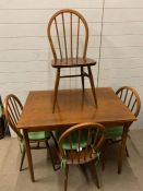 A Mid Century dining table with tapering legs and four bentwood spindle chairs