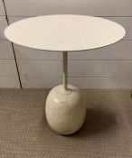 A Lato round sculptural table.A round table top balanced by on oval shape base. Design by Luca