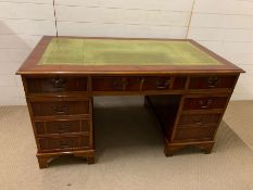 A mahogany pedestal desk with brass handles (H76cm W137cm D76cm)