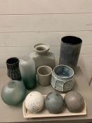 A selection of various blue and grey ceramics along with decorative spheres and vases.
