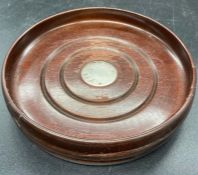 A Mahogany style decanter coaster with hallmarked silver center.