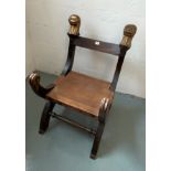 Statement chair composite wood and leather with carved monkey head finials. Leather seat has