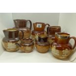 A quantity of Doulton Lambeth ware jugs/pitchers/teapot in various sizes including ; a silver