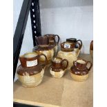 A quantity of Doulton Lambeth ware jugs/pitchers/vessels in various sizes including ; Queen Victoria
