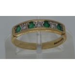 A 9ct yellow gold diamond and emerald half eternity ring, hallmarked 375 Birmingham, approx size L