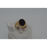 Gents 9ct yellow gold signet ring with oval Black stone, approx size R, fully hallmarked. Approx