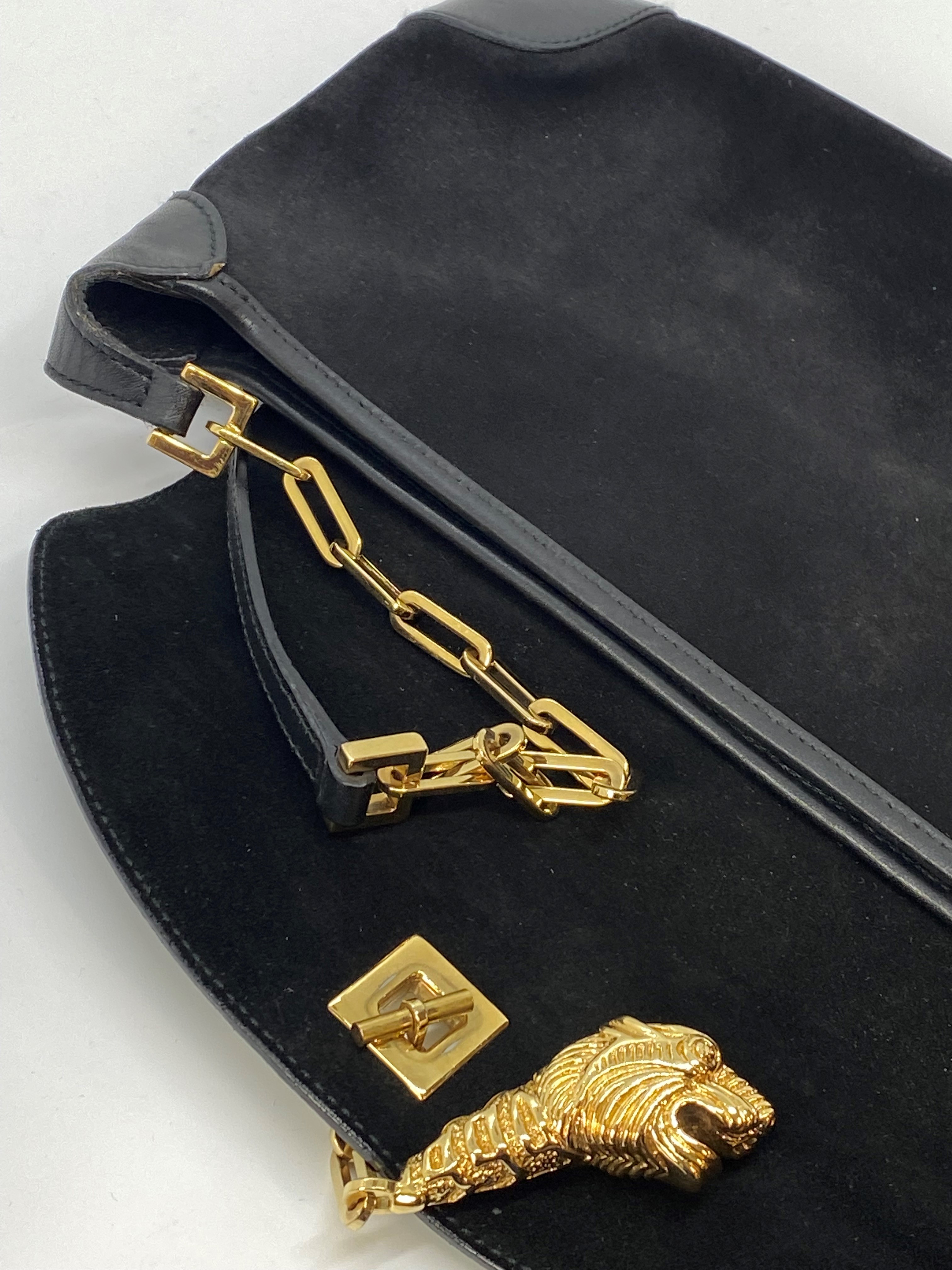 Gucci black suede shoulder bag, with a gold-tone tiger's head clasp and black leather detailing,