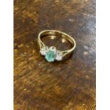 A 9ct yellow gold ring with oval green central stone and a diamond either side of shank, approx size