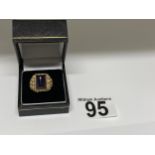 A 9ct yellow ring, hallmarked London with polished purple raised stone, with a patterned design to