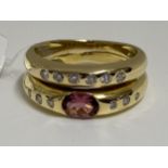 18ct yellow gold double band ring with diamonds set into both bands with central pink oval stone.