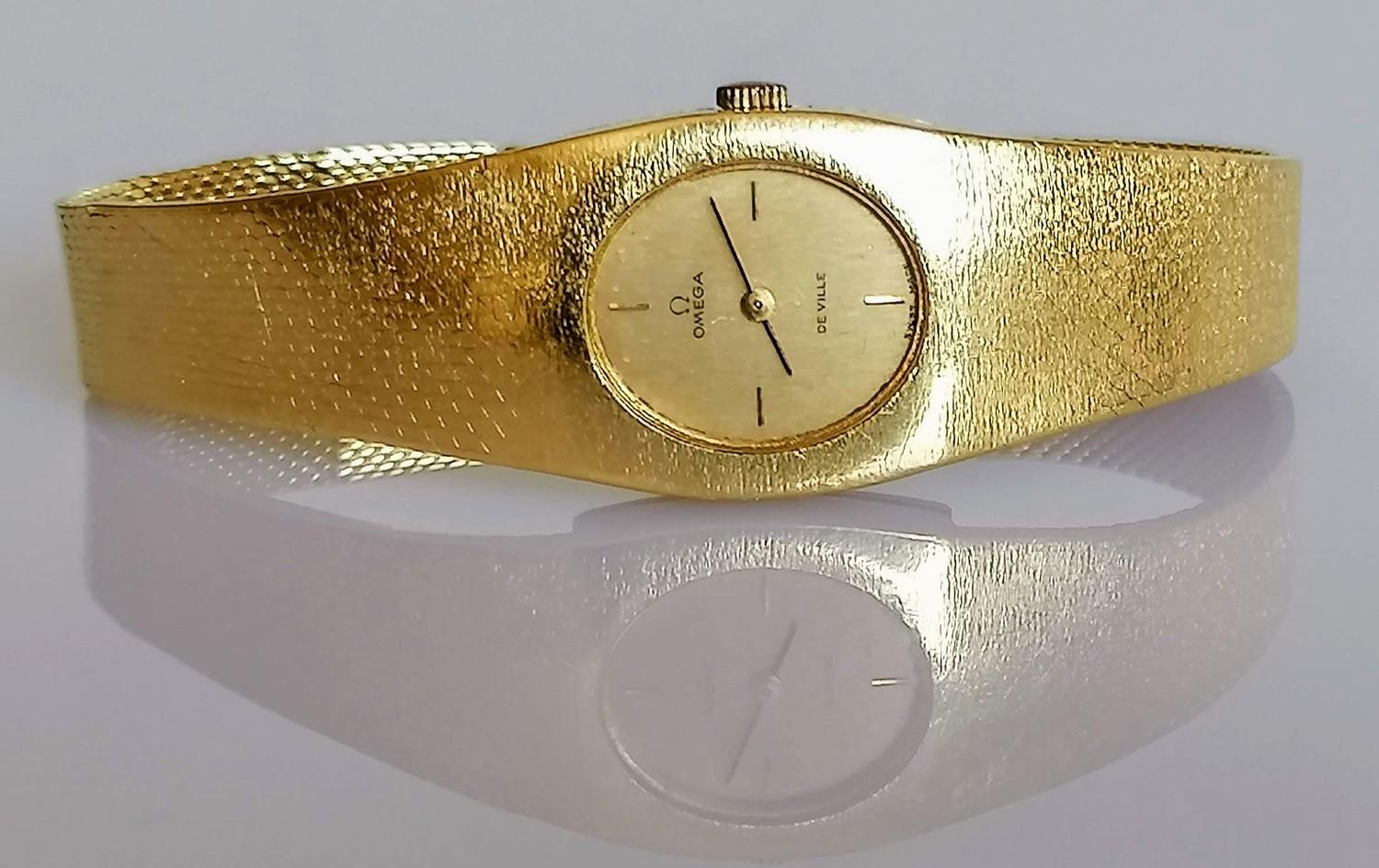 A ladies 18ct yellow gold Omega De Ville wristwatch, the rectangular case enclosing oval champagne