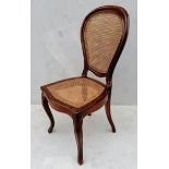 A 19th century French walnut-framed occasional chair with rattan seat and support on cabriole