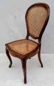 A 19th century French walnut-framed occasional chair with rattan seat and support on cabriole
