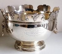 A Victorian silver monteith punch bowl with moulded rim, lion mask handles on a stepped pedestal