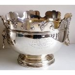 A Victorian silver monteith punch bowl with moulded rim, lion mask handles on a stepped pedestal