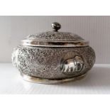 An Indian silver lidded jar with profuse embossed decoration, 7 x 11 cm diameter, with slight dents,