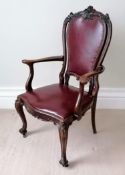 An Edwardian mahogany-framed library chair with red leather upholstery, carved supports on