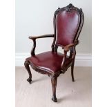 An Edwardian mahogany-framed library chair with red leather upholstery, carved supports on