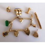 A 9ct gold charm bracelet with three loose charms, gold tooth pick, all hallmarked, 36.57g