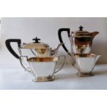 An Art Deco silver four-piece tea/coffee service with stylized design, reeded handles on stepped