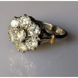 An yellow and white gold flower ring with seven brilliant-cut diamonds, each measuring approximately