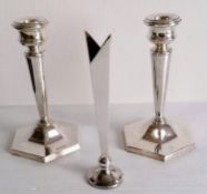 A matching pair of silver tapering candlesticks on hexagonal bases and a silver posy holder, all