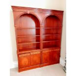 A Sheraton-style mahogany arcaded set of three open bookcases with blind fretwork to cornice and