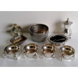 An Art & Crafts set of four circular silver salts with stylised handles by Sibray, Hall & Co Ltd.,