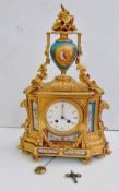 A 19th century French gilt mantle clock surmounted by a Sevres-style urn with classical depiction