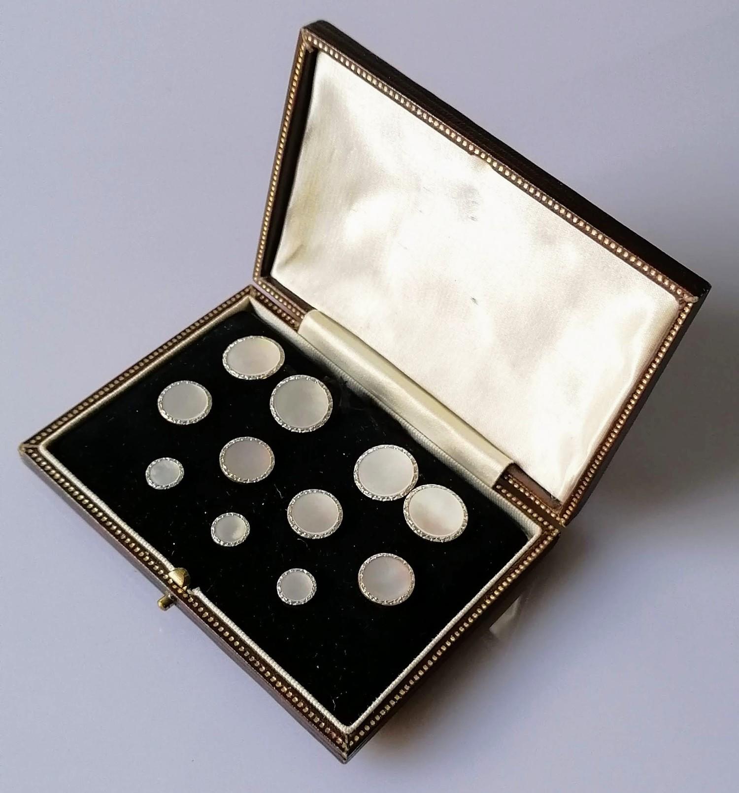 A cased mother of pearl and gold dress set comprising: a pair of double sided cufflinks, four