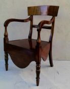 A George IV mahogany commode chair with shaped support, carved arms, lift-up seat on turned legs, 87