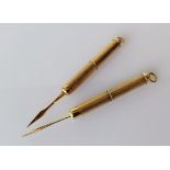 Two 9ct yellow gold tooth picks with engine turned design, each 7cm extended, hallmarked, 12.32g