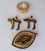 An elliptical gold pendant with spinning panel showing the Star of David and a menorah; a