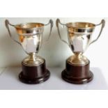 A pair of Art Deco two-handled trophy cups on bakelite bases by Alexander Clark & Co Ltd.,