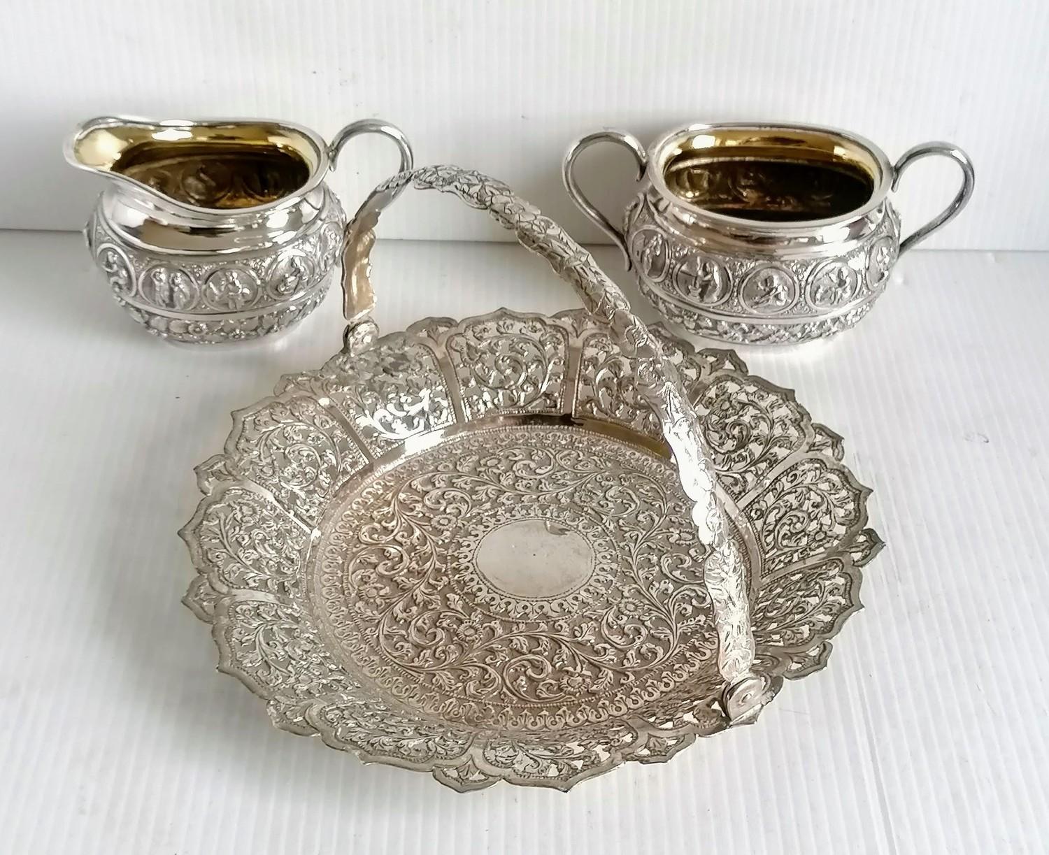 A colonial Indian silver two-handled sugar bowl, matching cream jug and tongs stamped silver and a