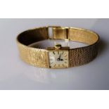 A mid-century Omega ladies dress watch with a gold case and bark-effect bracelet strap, in working