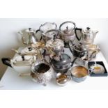 An assortment of silver plated tea kettles, coffee pots, etc