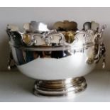 A Victorian silver monteith punch bowl with moulded rim, lion mask handles on a stepped pedestal