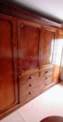 A late Georgian mahogany gentleman's wardrobe with shaped cornice, central cupboard comprising