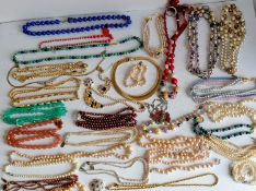 A large assortment of costume jewellery to include necklaces, chains, bracelets, etc