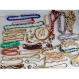 A large assortment of costume jewellery to include necklaces, chains, bracelets, etc
