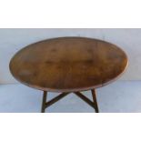 An Ercol beech and elm drop leaf table with X-shape stretcher, blue label, 72 cm H, 113 cm diameter,