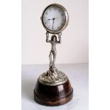 An Early 19th century figural clock in the form of a silver harlequin, the white dial with Arabic