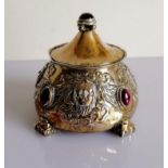 An Arts and Crafts silver pot and cover of circular tapering form, embossed with grotesque masks,