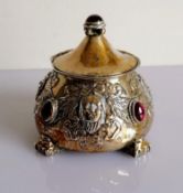 An Arts and Crafts silver pot and cover of circular tapering form, embossed with grotesque masks,